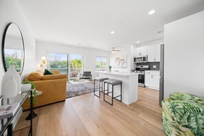 Um apartamento moderno com sala de estar, cozinha e varanda.