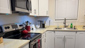 Eine moderne Küche mit weißen Schränken, Edelstahlgeräten und Holzboden.