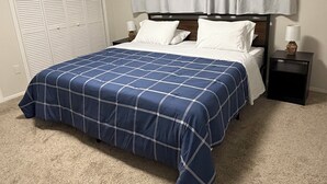 Ein Schlafzimmer mit Bett, Vorhängen, einem Nachttisch und einem Kleiderschrank.