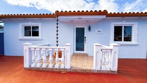 A white building with a tiled roof, a number '340' on the door, and a white balcony with balusters. - Stylish & Centrally Located Miami Stay / Free Parking & Fast WiFi (Miami)