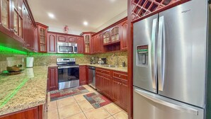 A kitchen with wooden cabinets, stainless steel appliances, and a green under-cabinet lighting. - Stylish & Centrally Located Miami Stay / Free Parking & Fast WiFi (Miami)