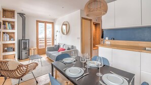 A modern kitchen with white cabinets, a wooden countertop, and a built-in stove. - Rochebrune Ski Terrace - Welkeys (Megève)