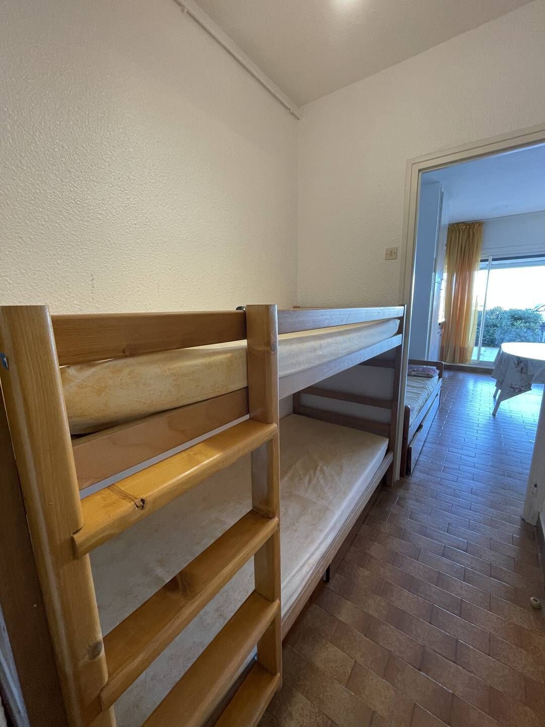 Quarto em dormitório com beliches e varanda.