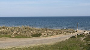 Una carretera costera que conduce al mar, con un farol y una señal.
