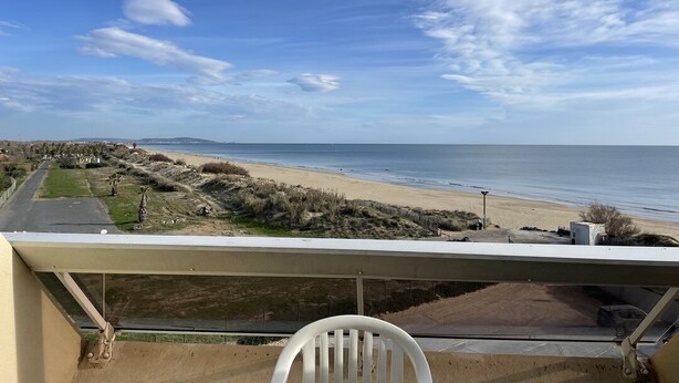 Un balcon avec vue sur la plage et l’océan.