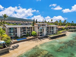 A beachfront hotel with multiple buildings, a swimming pool, and clear turquoise waters. - SUMMER SALE! Direct Oceanfront 2BR with Superb Views  - Nohonani 401 (Lahaina)