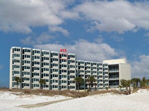 A multi-story hotel with a modern design, featuring a prominent number '815' on the facade. - Modern Beachfront Studio - Ocean View - Free Beach Chairs (Panama City Beach)