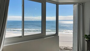 A room with a large bay window overlooking a beach. - Modern Beachfront Studio - Ocean View - Free Beach Chairs (Panama City Beach)