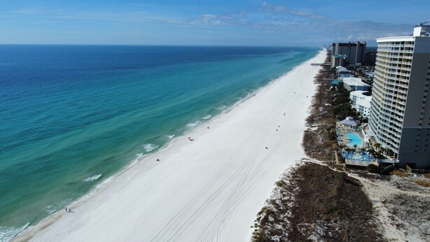 A beachside hotel with a large pool area, a beach, and ocean views. - Modern Beachfront Studio - Ocean View - Free Beach Chairs (Panama City Beach)