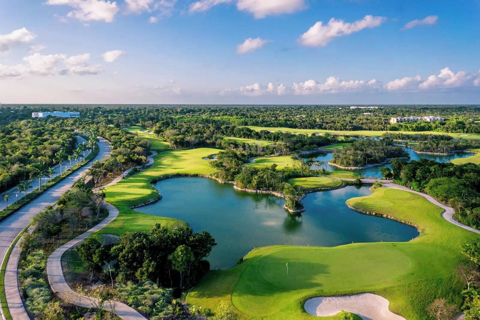 A golf course with multiple water hazards and a well-maintained fairway.