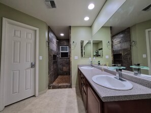 A bathroom with two sinks, a shower, and a large mirror. - Cozy Master Bedroom/Private Bathroom (Kihei)