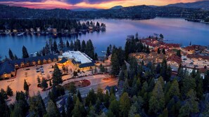 A lakeside hotel with a parking lot, a main building, and surrounding forested area. - Holiday Lake Cabin by Avantstay Large Deck + Cozy Fireplace + Near Arrowhead Village (Lake Arrowhead)
