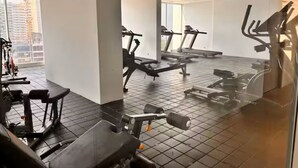 A gym with treadmills, weight machines, and a large window offering a city view. - Porto Horizonte Suite 1309-Suite in Hotel in Santa Marta (Santa Marta)