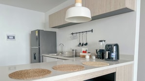 A modern kitchen with a central island, a built-in oven, a sink, and a coffee maker. - Porto Horizonte Suite 1309-Suite in Hotel in Santa Marta (Santa Marta)