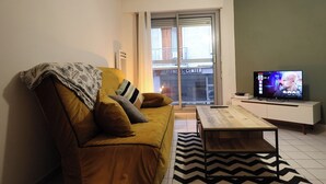 Ein Wohnzimmer mit einer Couch, einem Couchtisch und einem Fernseher.