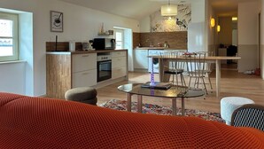 Eine moderne Küche mit Essbereich, einer Couch und einem Couchtisch.