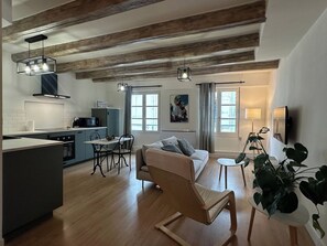 Een moderne keuken met een eethoek, een bank en een televisie.