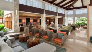 A spacious lobby with high ceilings, stone pillars, and a mix of seating areas including sofas and armchairs. - Dreams La Romana All Inclusive Resort & Spa (San Rafael del Yuma)
