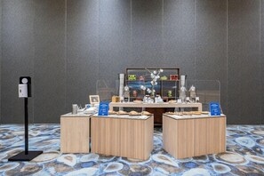 Una zona de recepción con un mostrador de madera, una exhibición de alimentos y un reloj en la pared.