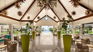 A spacious lobby with a high ceiling, large windows, and a view of a pool. - Dreams La Romana All Inclusive Resort & Spa (San Rafael del Yuma)