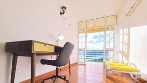 Una habitación con escritorio, silla y un banco.