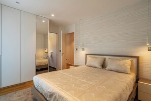 A bedroom with a bed, a wardrobe, and a mirror. - Renala II - Apart, With Pool, by Pausa H. Rentals (Funchal)