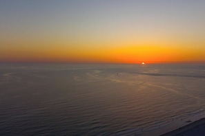 A wide view of a beach during sunset with calm waters and a clear sky. - Direct Gulf-Front 3BR, Sleeps 8  Huge Balcony, Pool & Private Garage (Indian Rocks Beach)
