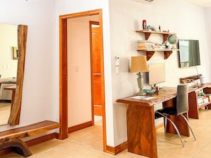 A modern living room with a wooden desk, a television, and a bookshelf.