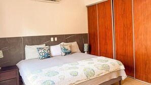 Ein Schlafzimmer mit Bett, Nachttisch und Kleiderschrank.