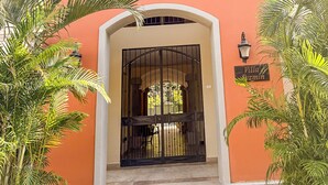 Ein Gebäude mit roter Fassade, einem verschlossenen Eingang und einem Schild mit der Aufschrift 'Villa Azmin'.