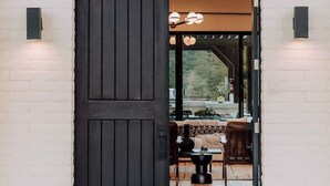 A black door with a white brick wall, a small table, and a bench inside. - Sierra Roja| Heated Pool, Spa, Gym, Sauna, Theater (Sedona)