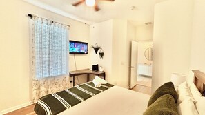 A hotel room with a bed, a television, a desk, and a bathroom visible through an open door. - 2632 Remodeled Getaway -heart of Disney (Kissimmee)