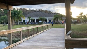 A wooden deck with a railing, leading to a building with a dark roof and white walls. - 2632 Remodeled Getaway -heart of Disney (Kissimmee)
