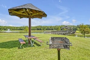 Ein Picknickplatz mit Grill, einer Holzpavillon und einem Steg über dem Wasser.