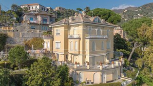 A multi-story building with balconies, surrounded by greenery and other buildings. - Laccadiva by Interhome (Zoagli)