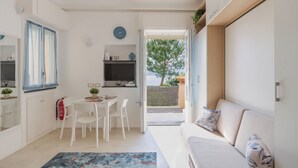 A modern kitchen with a dining area, a sofa, and a view of the outdoors. - Laccadiva by Interhome (Zoagli)