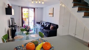 Een moderne woonkamer met een glazen salontafel, een bank en een trap.