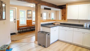 Una cocina moderna con armarios blancos, lavavajillas integrado y refrigerador compacto.