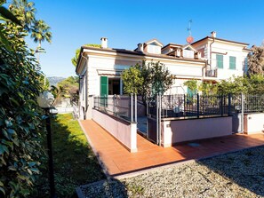 Ein zweistöckiges Haus mit Balkon, Garten und Blick ins Grüne.