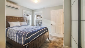 Een slaapkamer met een houten bed, een raam en een deur.