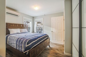 Ein Schlafzimmer mit einem hölzernen Bett, einem Fenster und einer Tür.