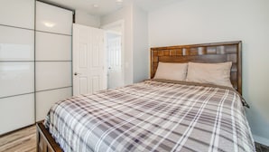 Een slaapkamer met een bed, een kledingkast en een deur.