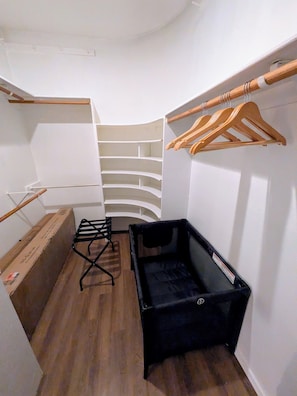 A compact room with a built-in wardrobe, a small seating area, and a wooden hanger rack. - Luxury Tigris House • Hot Tub • King Suites • Near Trails (Sedona)