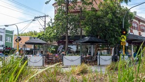 Straatbeeld met terras aan een café, een zebrapad en een maximumsnelheid bord.