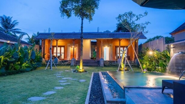 A villa with a swimming pool, a covered patio, and a well-maintained garden. - Rana Suite (Ubud)