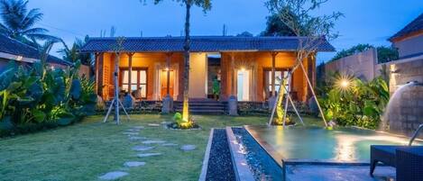 Una piscina al aire libre, sombrillas, sillones reclinables de piscina