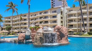 A hotel with a pool featuring a waterfall and rock formations. - Beachside Studio Near Downtown Puerto Vallarta (Puerto Vallarta)