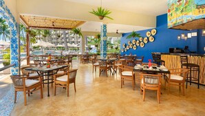 A restaurant with outdoor seating, a pool view, and a mural on the wall. - Beachside Studio Near Downtown Puerto Vallarta (Puerto Vallarta)