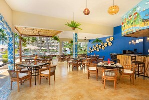Ein Restaurant mit Außenbereich, Blick auf den Pool und Wandmalerei.