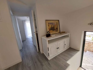 Ein Flur mit einem weißen Schrank und einem gerahmten Bild darauf.